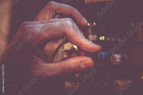 Man s hand adjusting the volume in a music synthesizer. Retro style.