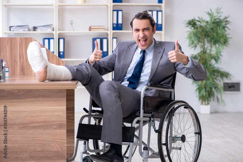 Male employee in wheel-chair in the office Male employee in wheel-chair in the office