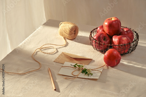 A letter and red apples on table. photo