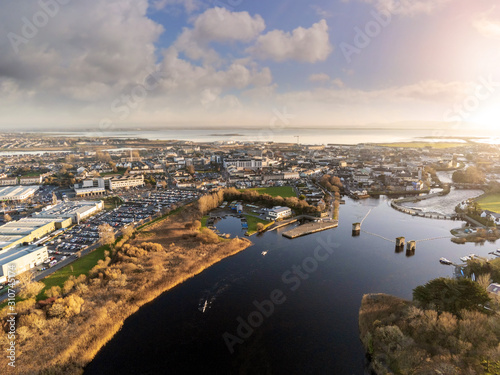 Aerial view on Galway city and river Corrib, Boats practicing, sunset time, Cloudy sky, Ireland, West coast.