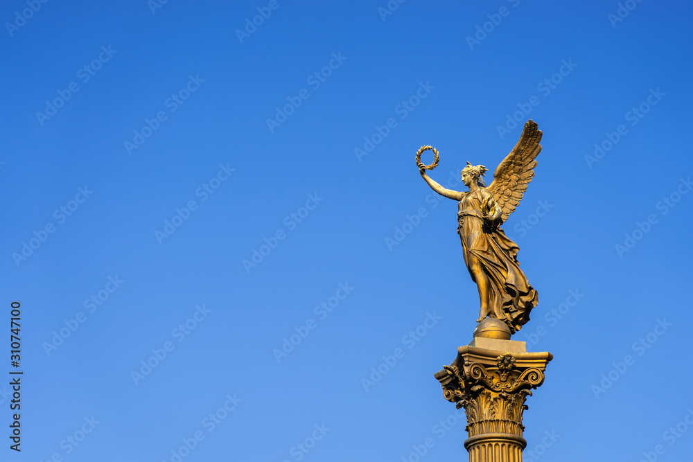 Fototapeta premium Gold lady monument on a blue sky background, Prague, horizontal