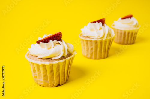 Cakes with white cream and strawberry filling on a yellow background. Baking and sweets.