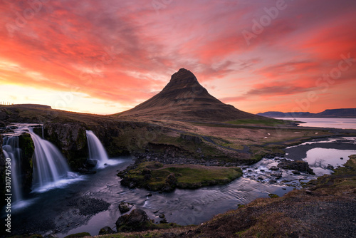 Pink skies over the famous kirkjufellsfoss waterfall in the icelandic landscape during sunset. Traveling and landscapes concept.