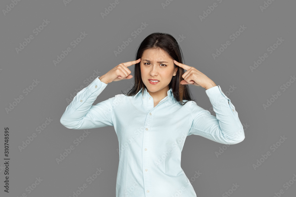 Freestyle. Young woman standing isolated on grey pointing at head irritated Freestyle. Young woman standing isolated on grey pointing at head irritated