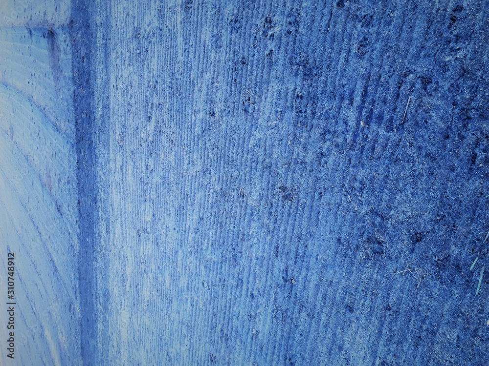  close-up of the earth's surface with a bokeh effect and a characteristic rough porous texture, abstract dark and light spots on a classic blue background