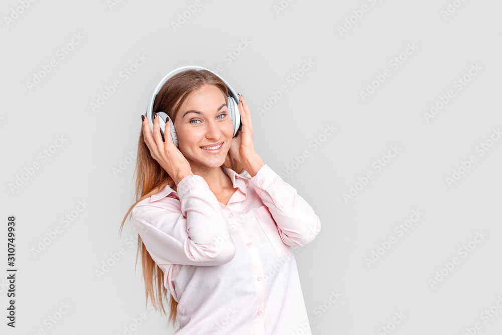 Freestyle. Young woman in headphones standing isolated on white listening to music joyful Freestyle. Young woman in headphones standing isolated on white listening to music joyful