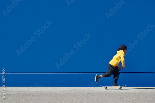 Ethnic man on skateboard on street