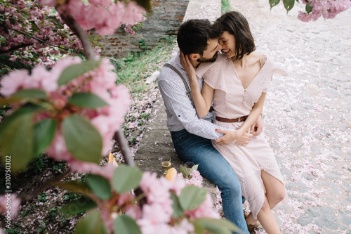 Young couple having picnic under cherry tree