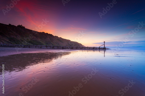 Fototapete Sunset colours with wet reflections on the beach in Mundesley, North Norfolk, UK