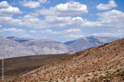 Obraz na płótnie Mojave Desert. In southern California, southeast of Sierra Nevada, north and east of Los Angeles, North America. Rocks are brown and gray. Clouds in the blue sky w salonie