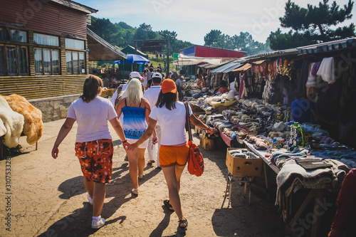 Open market with local goods on Kanatnoy Dorogi or Ay Petri village above Yalta in Crimea penninsula. Tourists walking past the stalls with clothing, food and other goods.