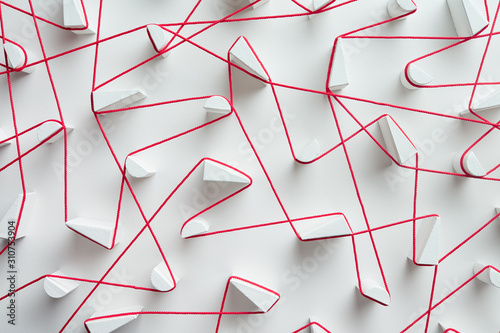 Interweaving red strings on white background