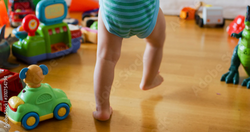 Little toddler legs of a baby boy walking on floor at home