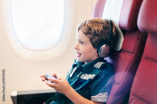 Boy playing an electronic game on an airplane