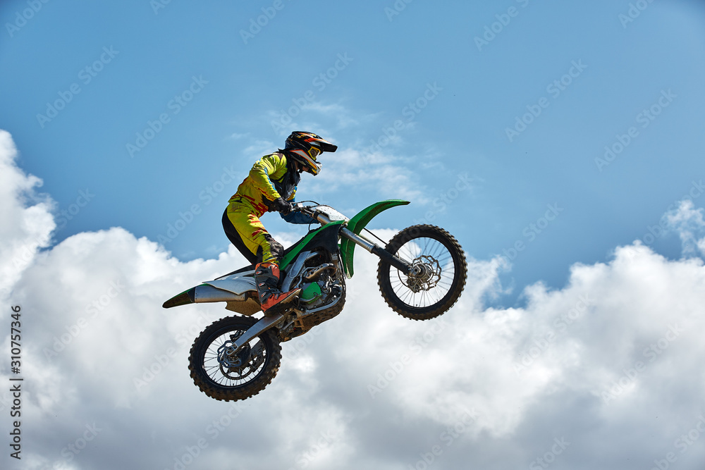 Extreme sports, motorcycle jumping. Motorcyclist makes an extreme jump against the sky. Film grain effect, illumination Extreme sports, motorcycle jumping. Motorcyclist makes an extreme jump against the sky. Film grain effect, illumination