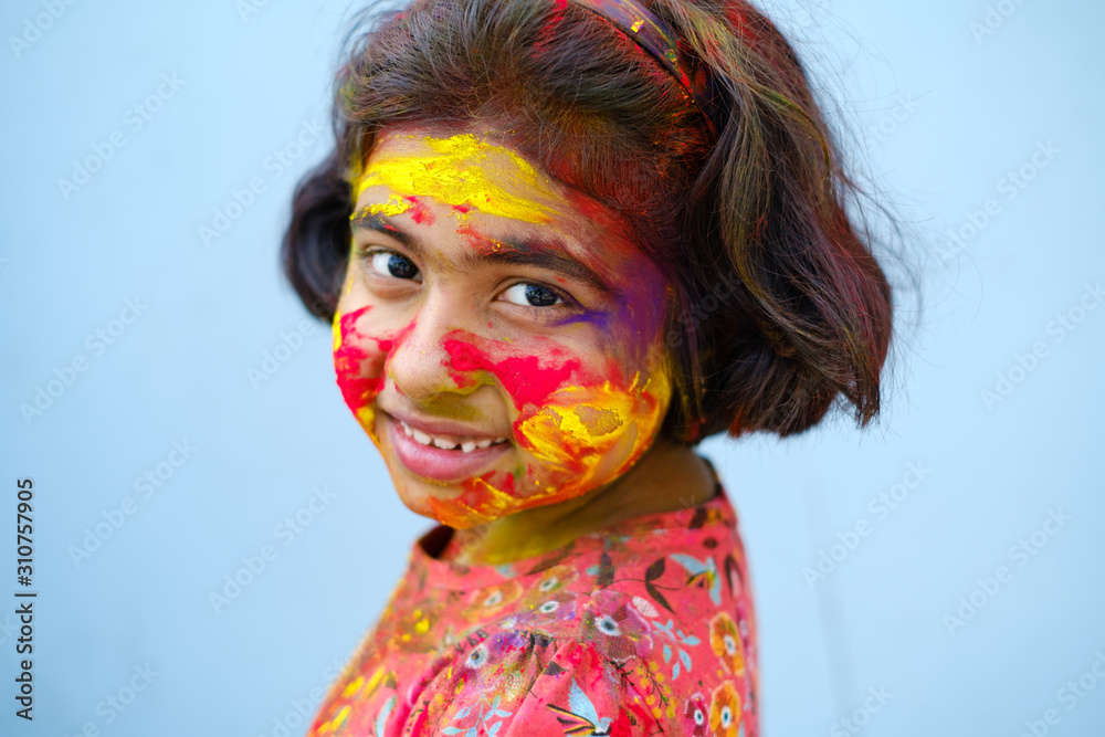 close up portrait of cute little girl smeared with color powder during holi celebration close up portrait of cute little girl smeared with color powder during holi celebration