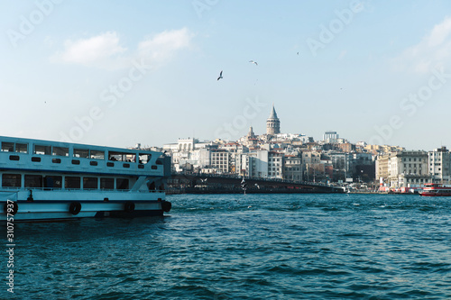 Boat on water near city on shore. Galata Kˆpr¸s¸. Galata Bridge in Istanbul. photo