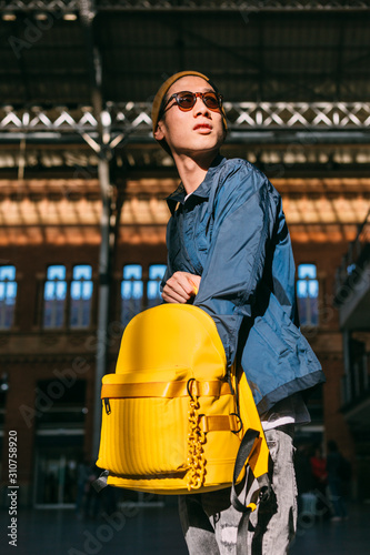 Asian young man searching something inside his backpack photo