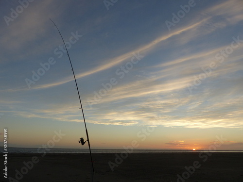 Surf casting fishing rod on Foxton beach at sunset in New Zealand