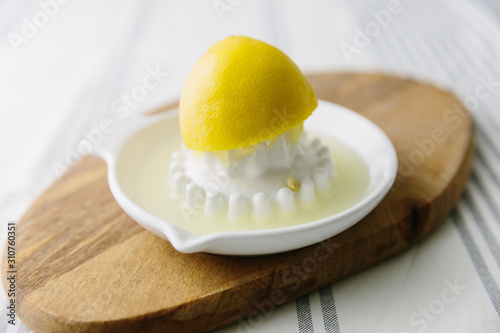 Freshly squeezed lemon juice on ceramic fruit juicer photo