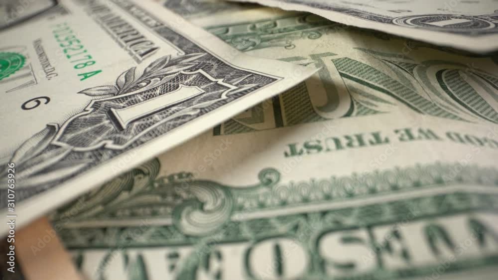 Small denominated dollar bills rotate on a table. Close-up Small denominated dollar bills rotate on a table. Close-up