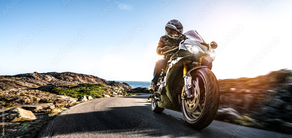 Fototapeta motocykl na nadmorskiej drodze. dobrze się bawisz jadąc pustą autostradą podczas wycieczki motocyklowej