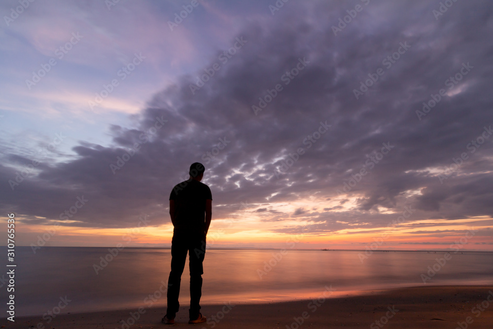 silhouette of man on the beach at beautiful sunset.