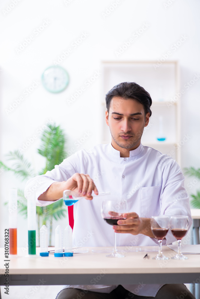 Male chemist examining wine samples at lab Male chemist examining wine samples at lab