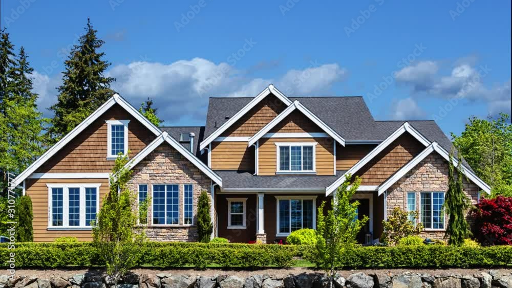 Modern American custom home with blue sky and puffy clouds passing by in the background