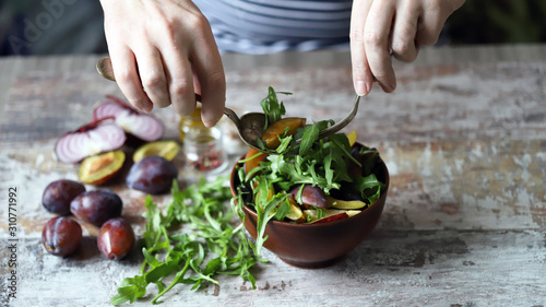 Healthy arugula plum salad. Selective focus. Macro.