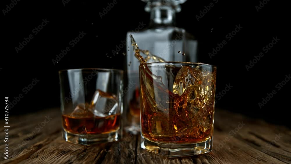 Super Slow Motion Shot of Ice Drop into Glass with Whiskey at 1000fps with Camera Movement. Super Slow Motion Shot of Ice Drop into Glass with Whiskey at 1000fps with Camera Movement.