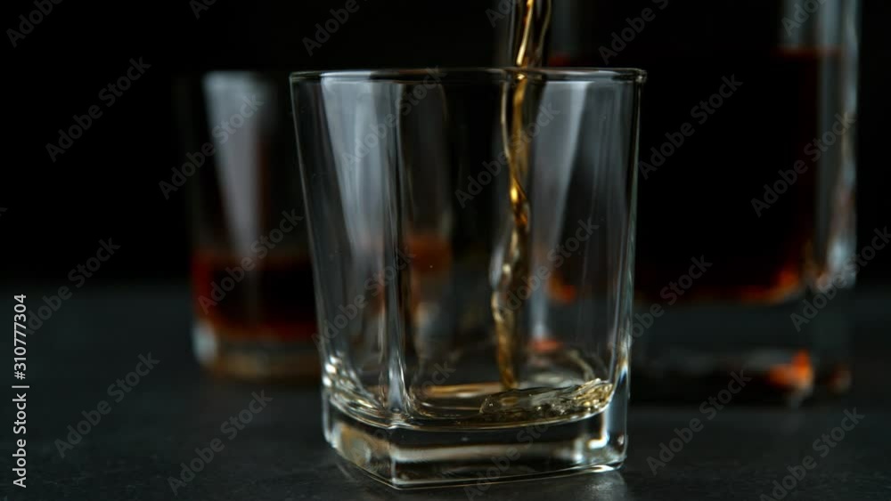 Super Slow Motion Shot of Pouring Whiskey into Glass at 1000fps with Camera Movement. Super Slow Motion Shot of Pouring Whiskey into Glass at 1000fps with Camera Movement.
