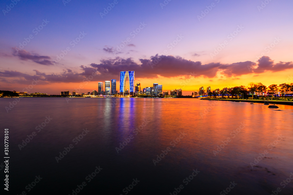 Suzhou city skyline and water reflection at night.