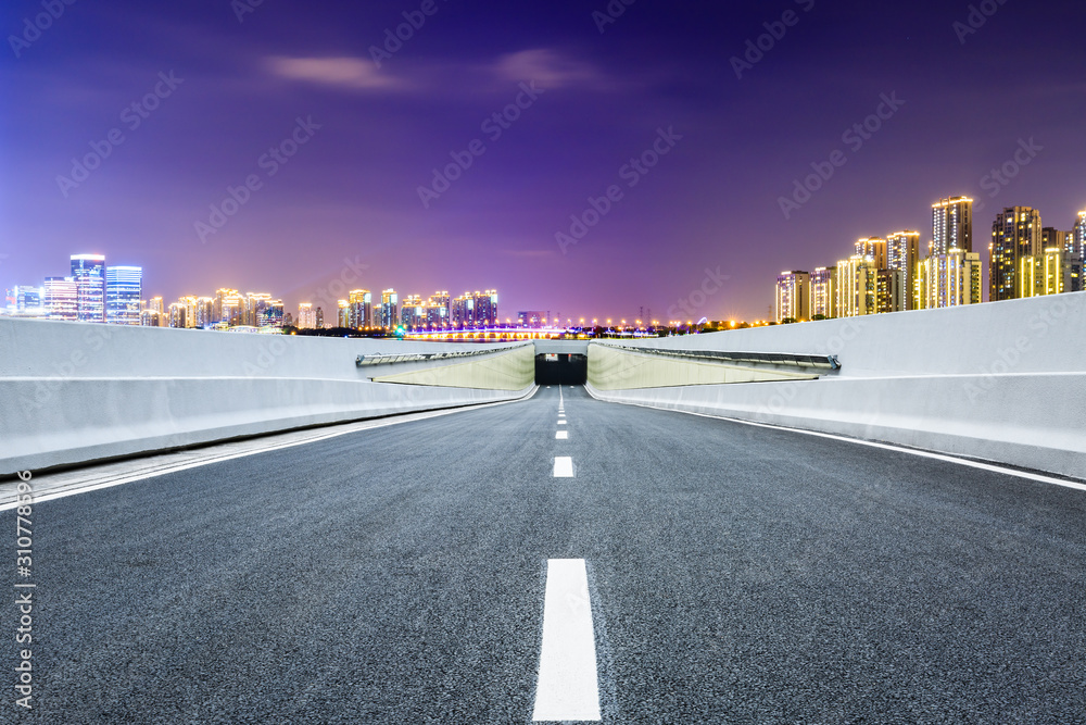 Asphalt road and Suzhou city skyline with beautiful colorful clouds at night.