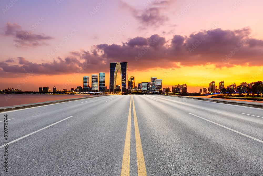 Asphalt road and Suzhou city skyline with beautiful colorful clouds at sunset. - obrazy, fototapety, plakaty 