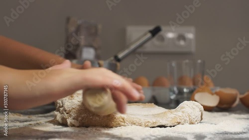 Little girl chef diligently rolls out pizza dough. Slow motion