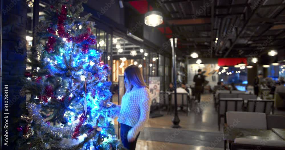 Girl examines the Christmas tree. Girl examines the Christmas tree.