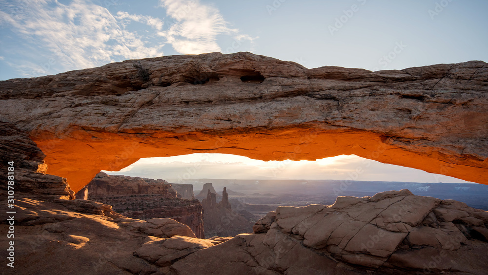 Sunrise of Mesa Arch lighting up and glowing in the Utah desert of Canyonlands.