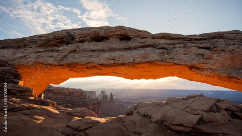 Sunrise of Mesa Arch lighting up and glowing in the Utah desert of Canyonlands.