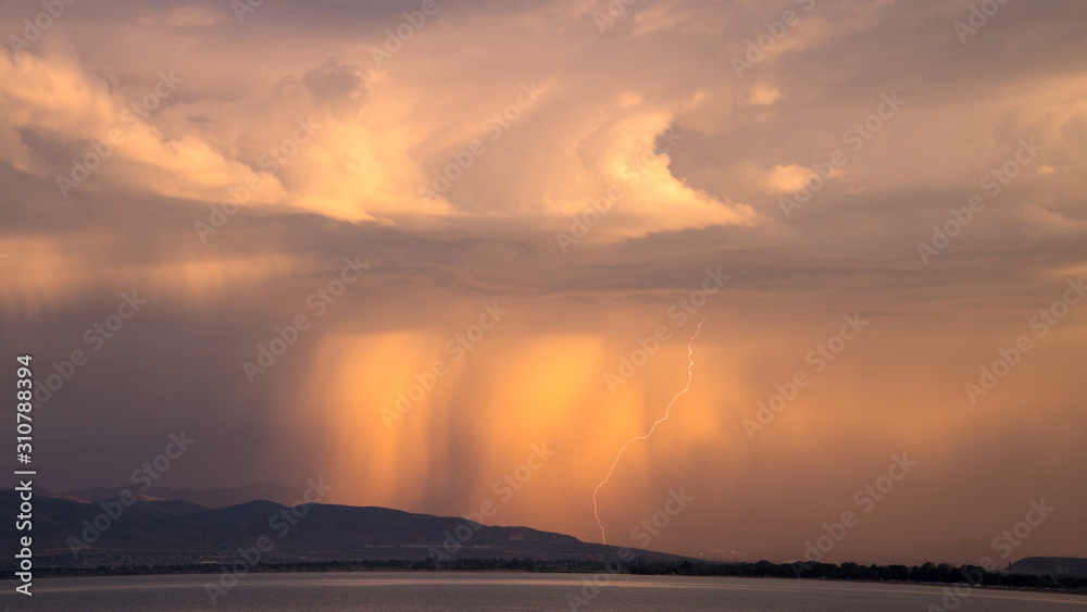 Naklejka premium Sunrise storm with lightning strike looking past Utah Lake.