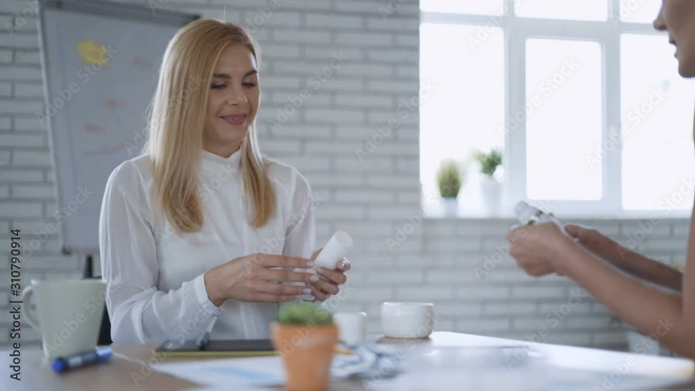 Two blonde women are testing cosmetics for sale at the office. care cosmetics concept 4K Two blonde women are testing cosmetics for sale at the office. care cosmetics concept 4K