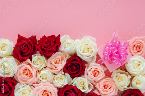 Colorful roses put on pink background with pink gift box for Valentine   s day. Flat lay background concept.