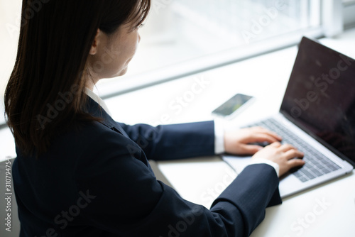 オフィスでパソコンを使って働く女性