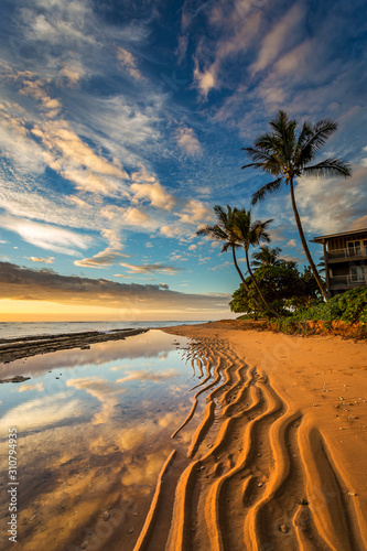 Kauai Beach Sunrise, ripples in the sand, reflection of an amazing sky and palm trees.