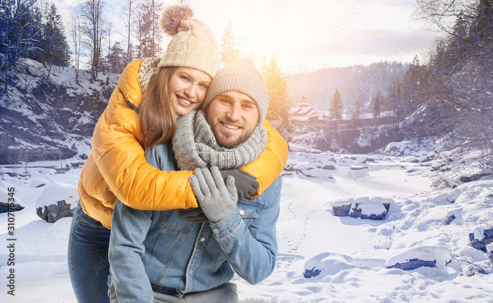 Portrait of happy couple near mountain stream on winter day