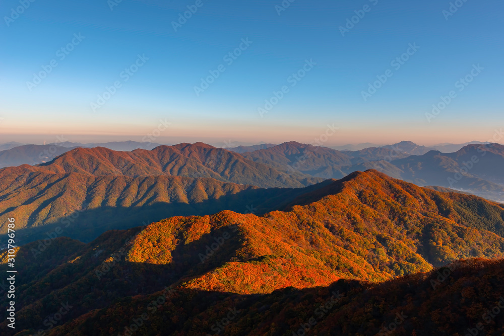 Fototapeta premium The horizon line is normally covered with morning mist in autumn on the peak of Chunmasan Mountain in Seoul, South Korea.