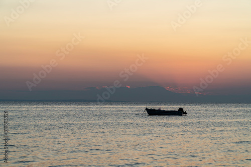 Boat in the middle of the sea during sunset © nikolay100