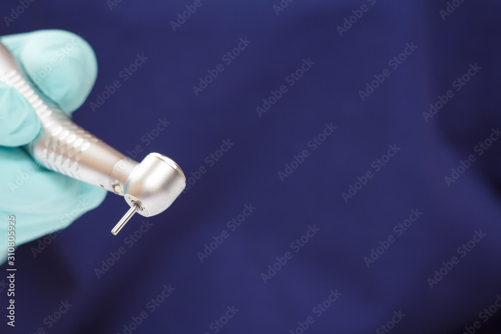 Dentist's hand in glove with dental handpiece. Dentist's hand in glove with dental handpiece.