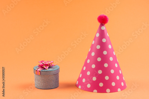 Blue present box with pink bow in a shopping cart and birthday cap