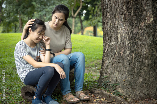 Asian woman give advice,talking sharing thoughts care,support to teenage girl,loving mother speak have comforting and consoling her daughter,sad crying from her friend’s problems,consultation concept © Satjawat